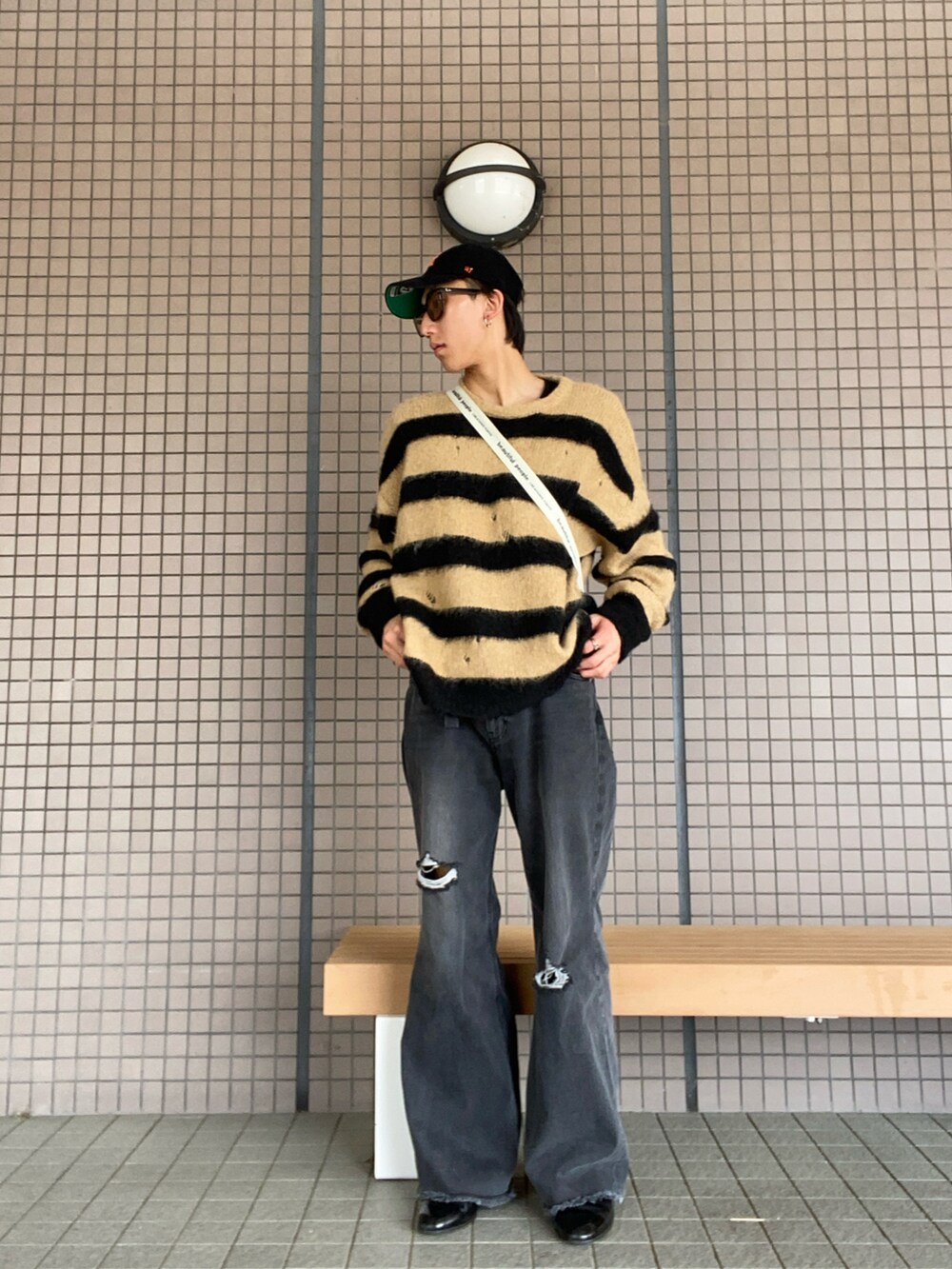 ホワイト系のショルダーバッグ、イエロー系のニット/セーター、グレー系のデニムパンツを着用したメンズの春コーディネートの2枚目の写真