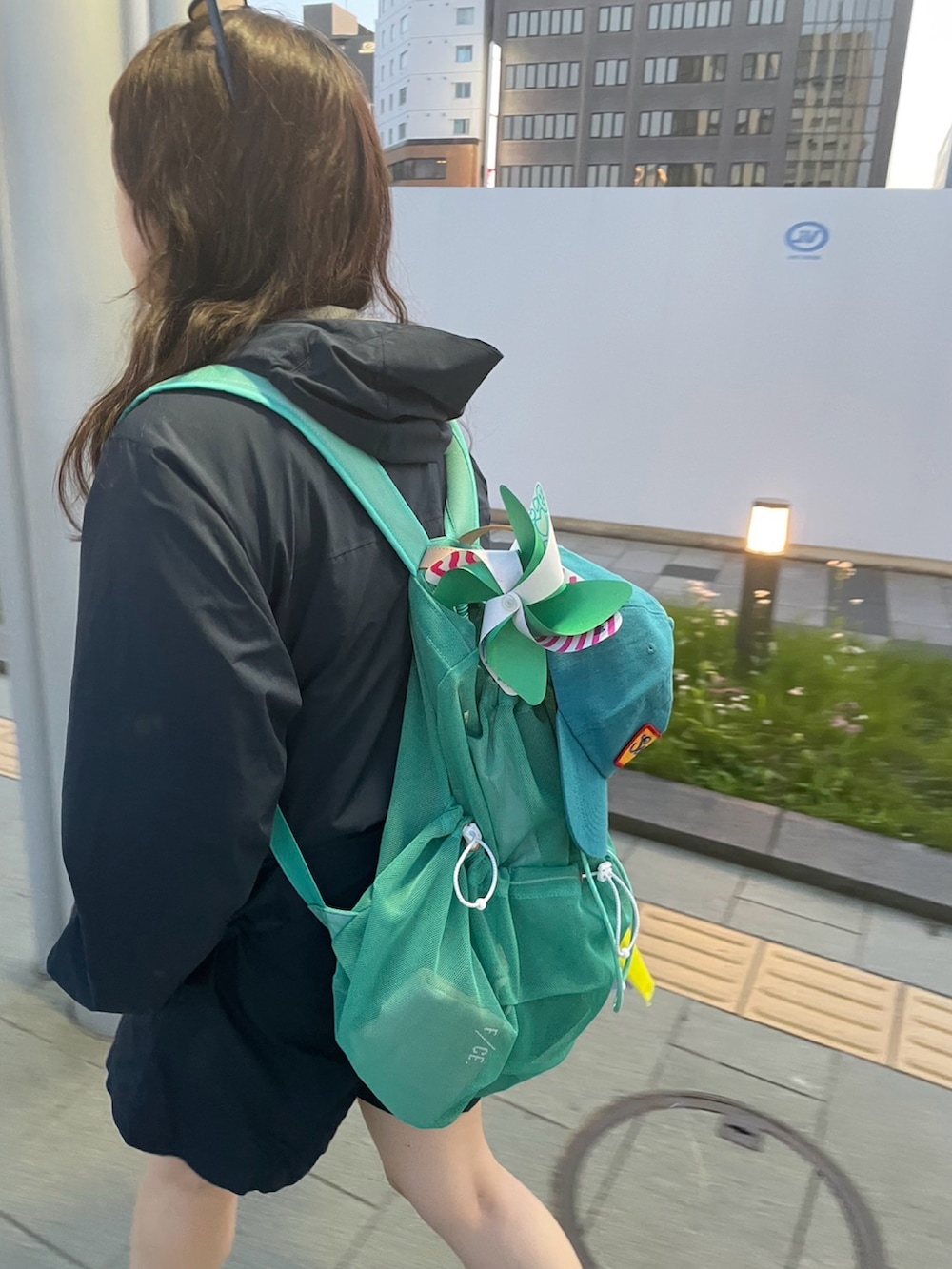 グリーン系のバックパック/リュック、ホワイト系のスニーカー、ブルー系のその他パンツを着用したレディースの秋コーディネートの2枚目の写真