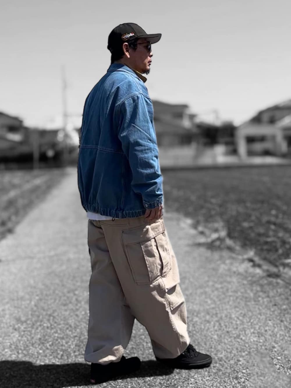 ブルー系のデニムジャケット、イエロー系のTシャツ/カットソー、ベージュ系のカーゴパンツを着用したメンズの春コーディネートの2枚目の写真