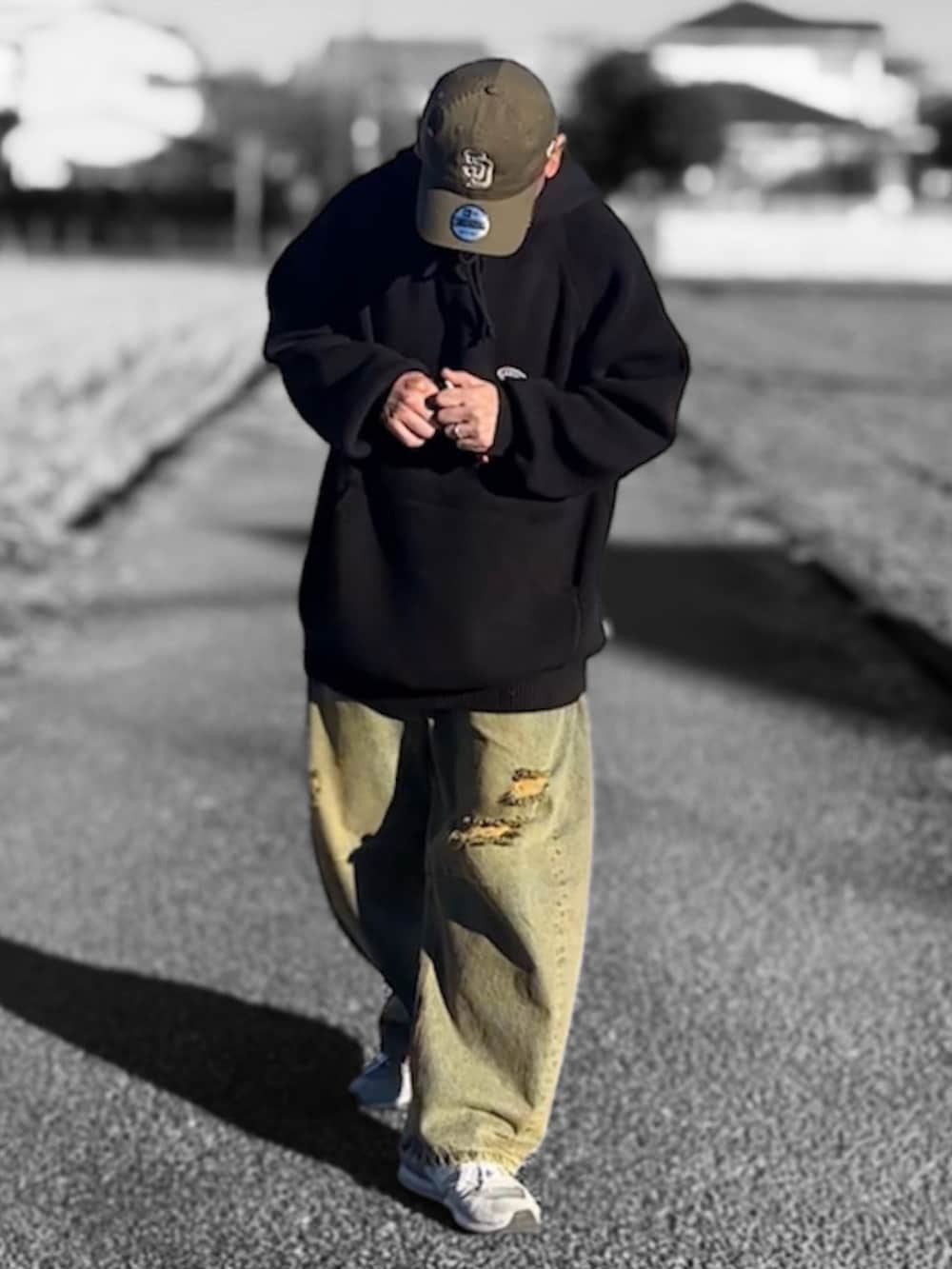 ブルー系のデニムパンツ、ブラック系のパーカー、ブラウン系のキャップを着用したメンズの冬コーディネートの2枚目の写真