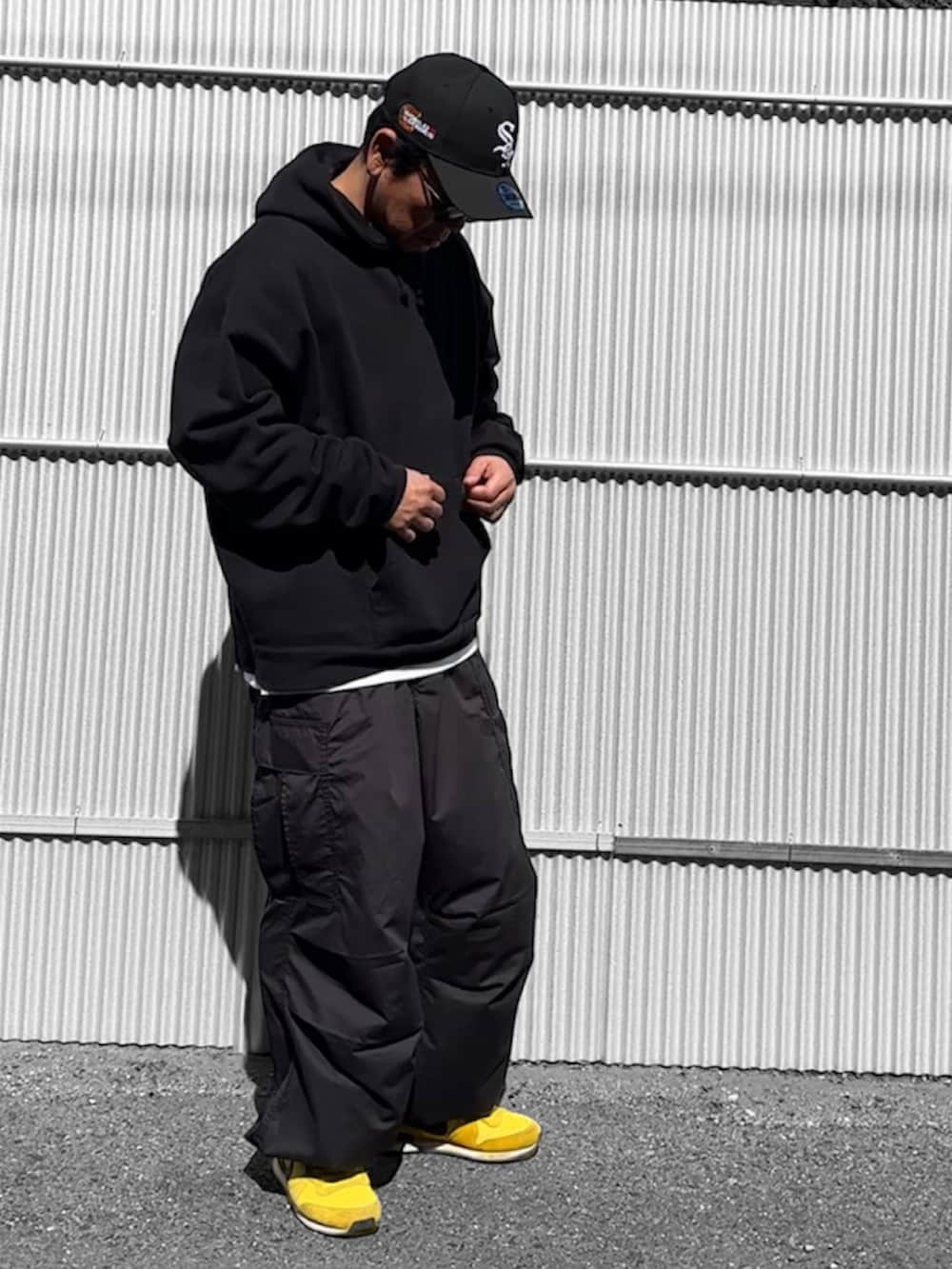 ブラック系のパーカー、ブラック系のカーゴパンツ、ブラック系のキャップを着用したメンズの冬コーディネートの2枚目の写真