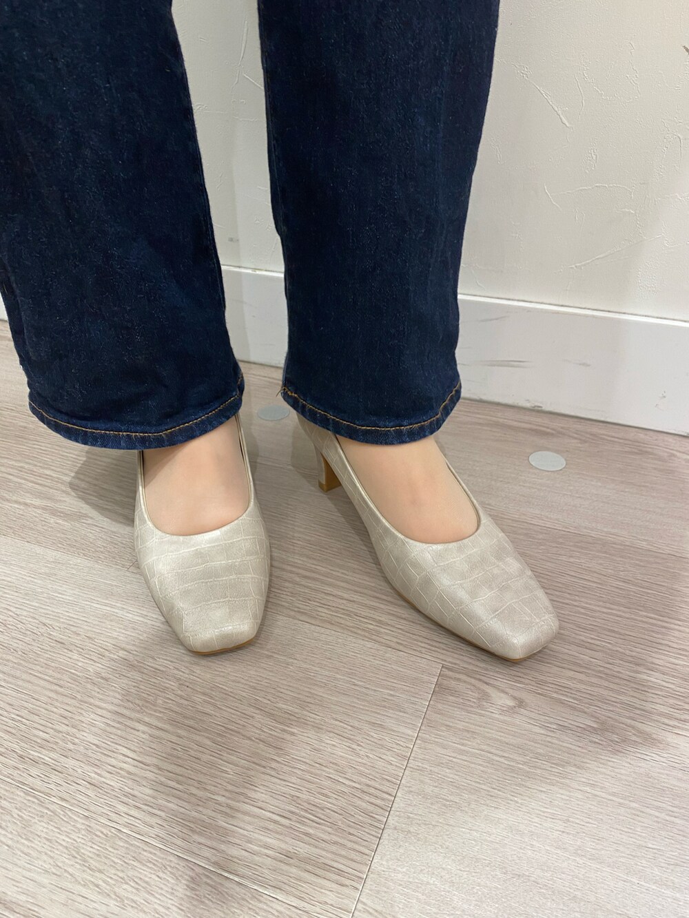 グレー系のパンプスを着用したレディースの秋コーディネートの2枚目の写真