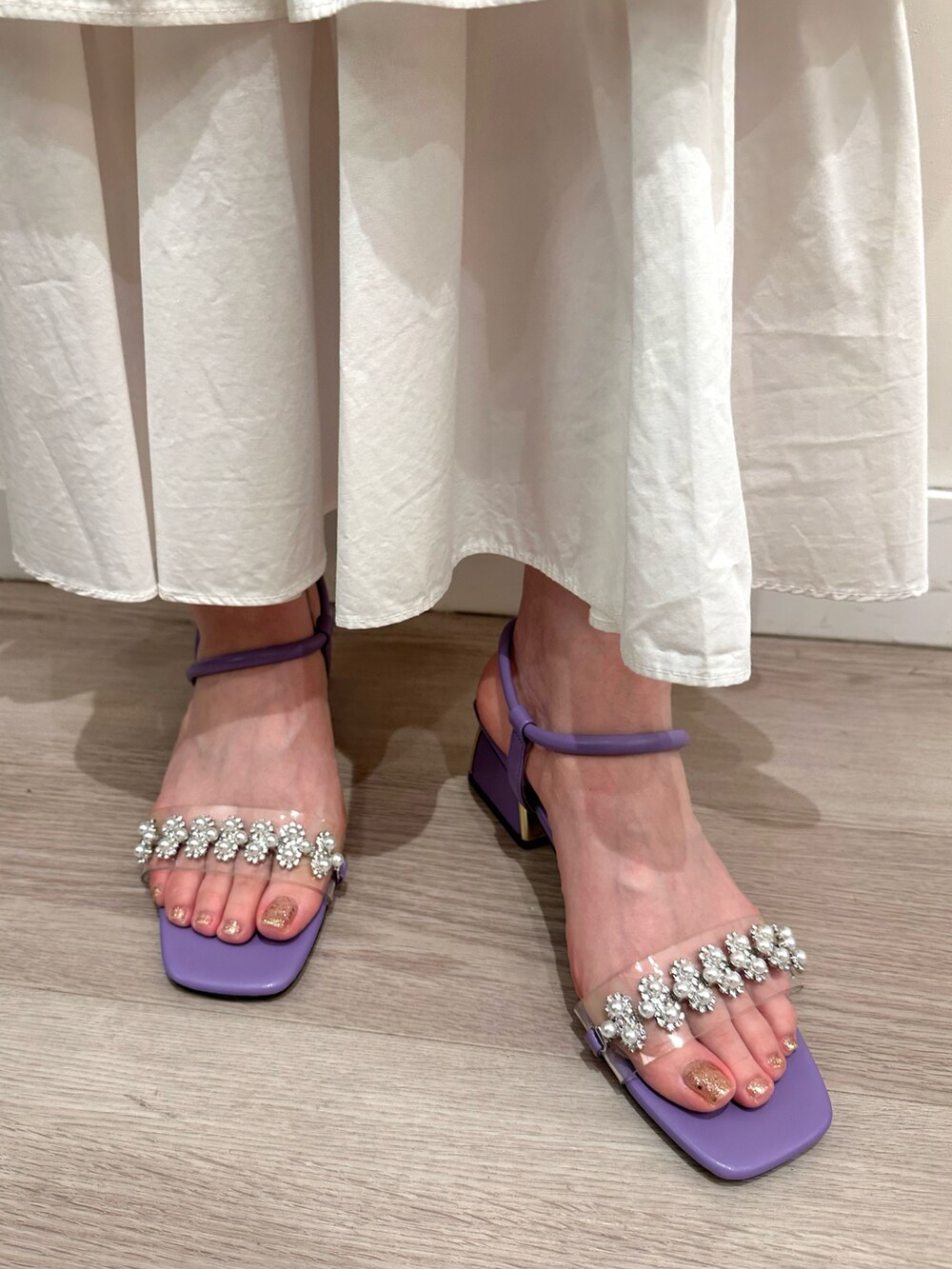 パープル系のサンダルを着用したレディースの春コーディネートの2枚目の写真