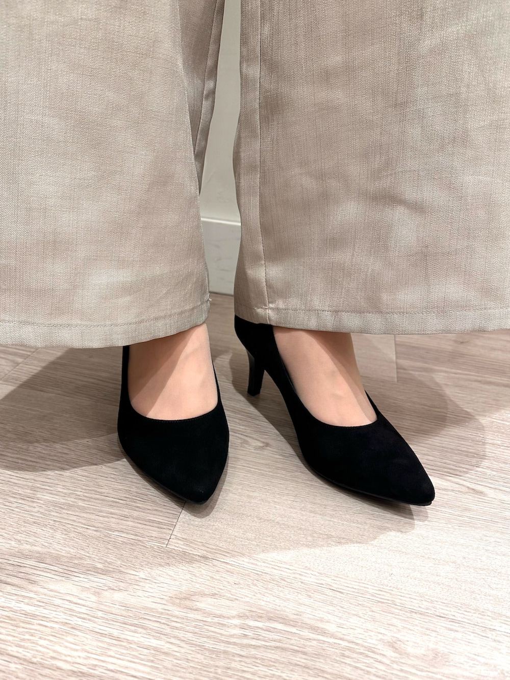 ブラック系のパンプスを着用したレディースの冬コーディネートの2枚目の写真