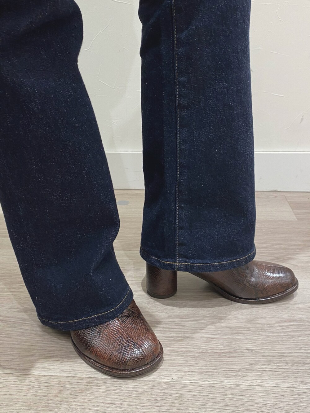 ブラウン系のブーツ、ブルー系のデニムパンツを着用したレディースの秋コーディネートの2枚目の写真