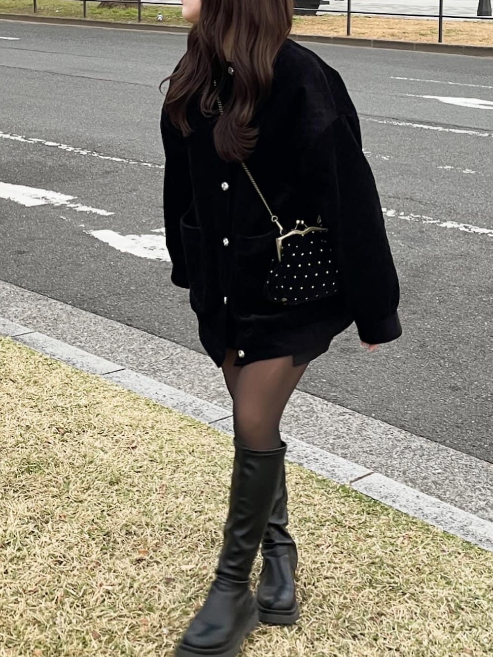 ブラック系のジャケット/アウター、ブラック系のショルダーバッグ、ブラック系のブーツを着用したレディースの冬コーディネートの3枚目の写真