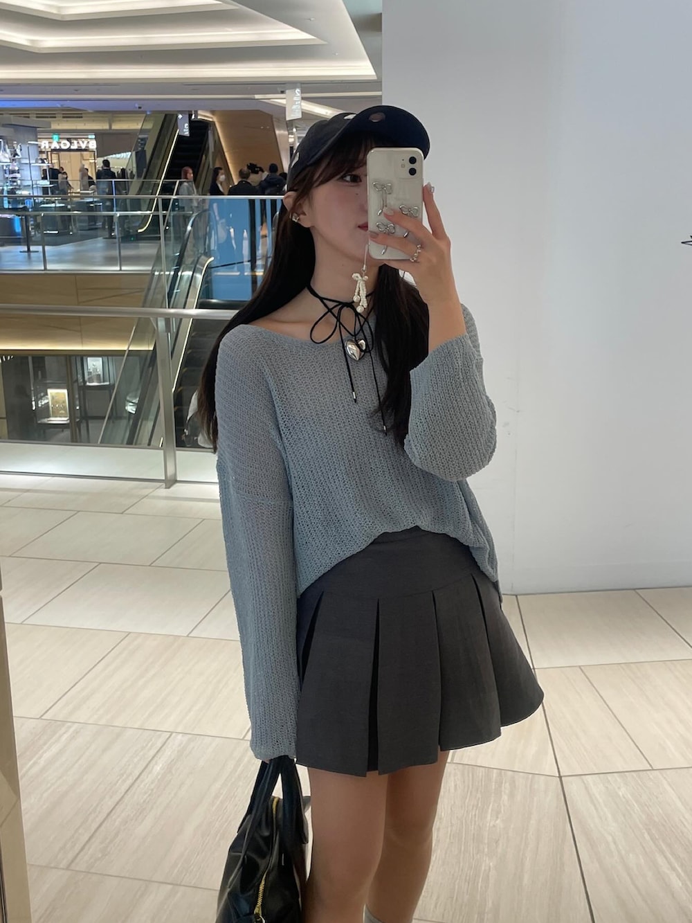 ブルー系のニット/セーター、ブラック系のハンドバッグ、ブラック系のスニーカーを着用したレディースの冬コーディネートの4枚目の写真