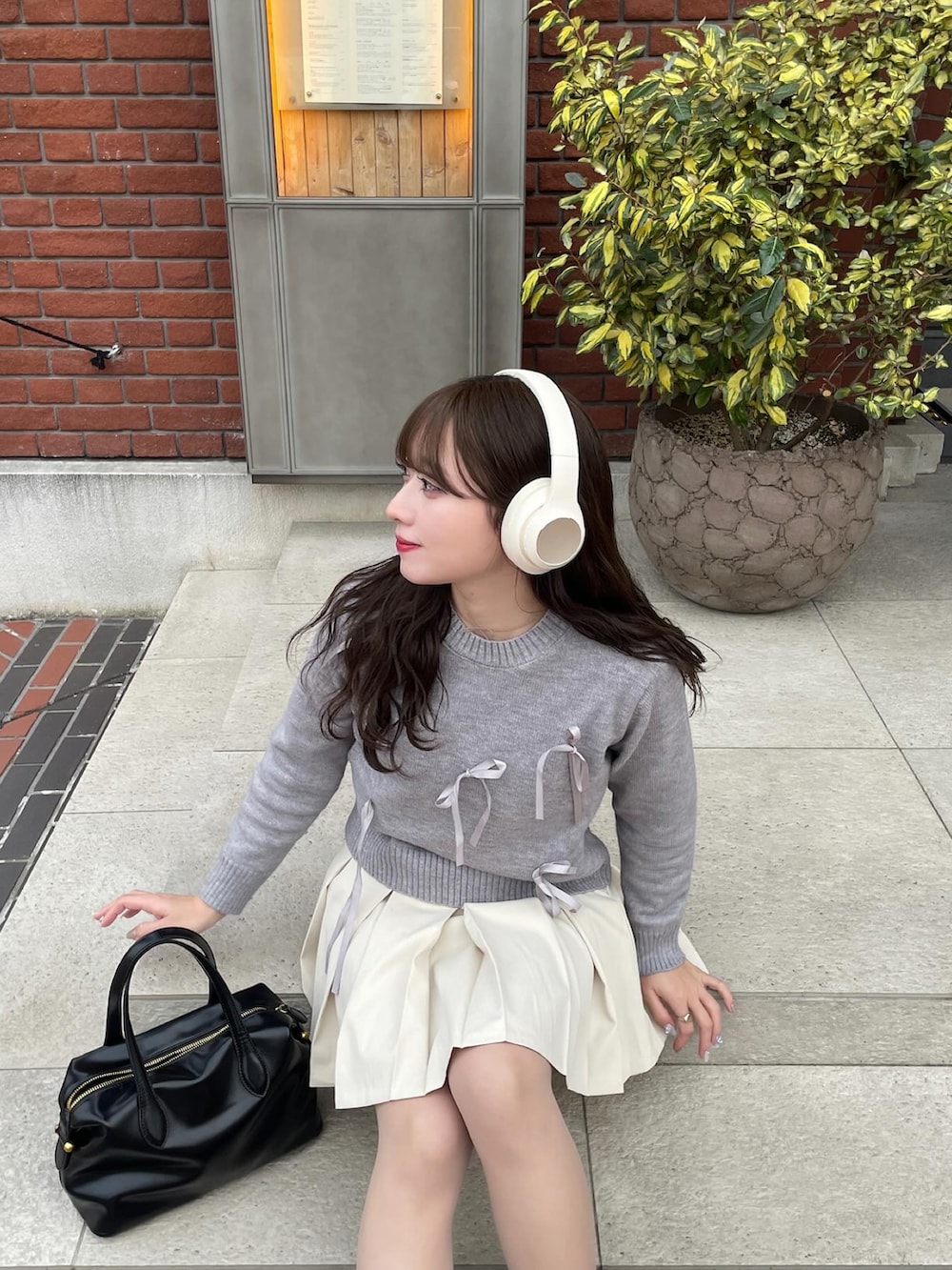 ブラック系のスニーカー、グレー系のニット/セーターを着用したレディースの冬コーディネートの4枚目の写真