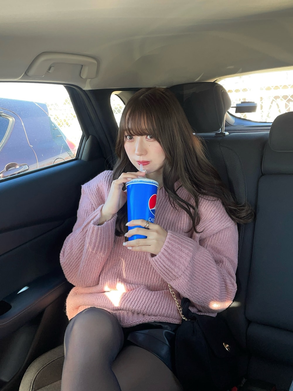 ピンク系のニット/セーター、ブラック系のパンツを着用したレディースの冬コーディネートの3枚目の写真