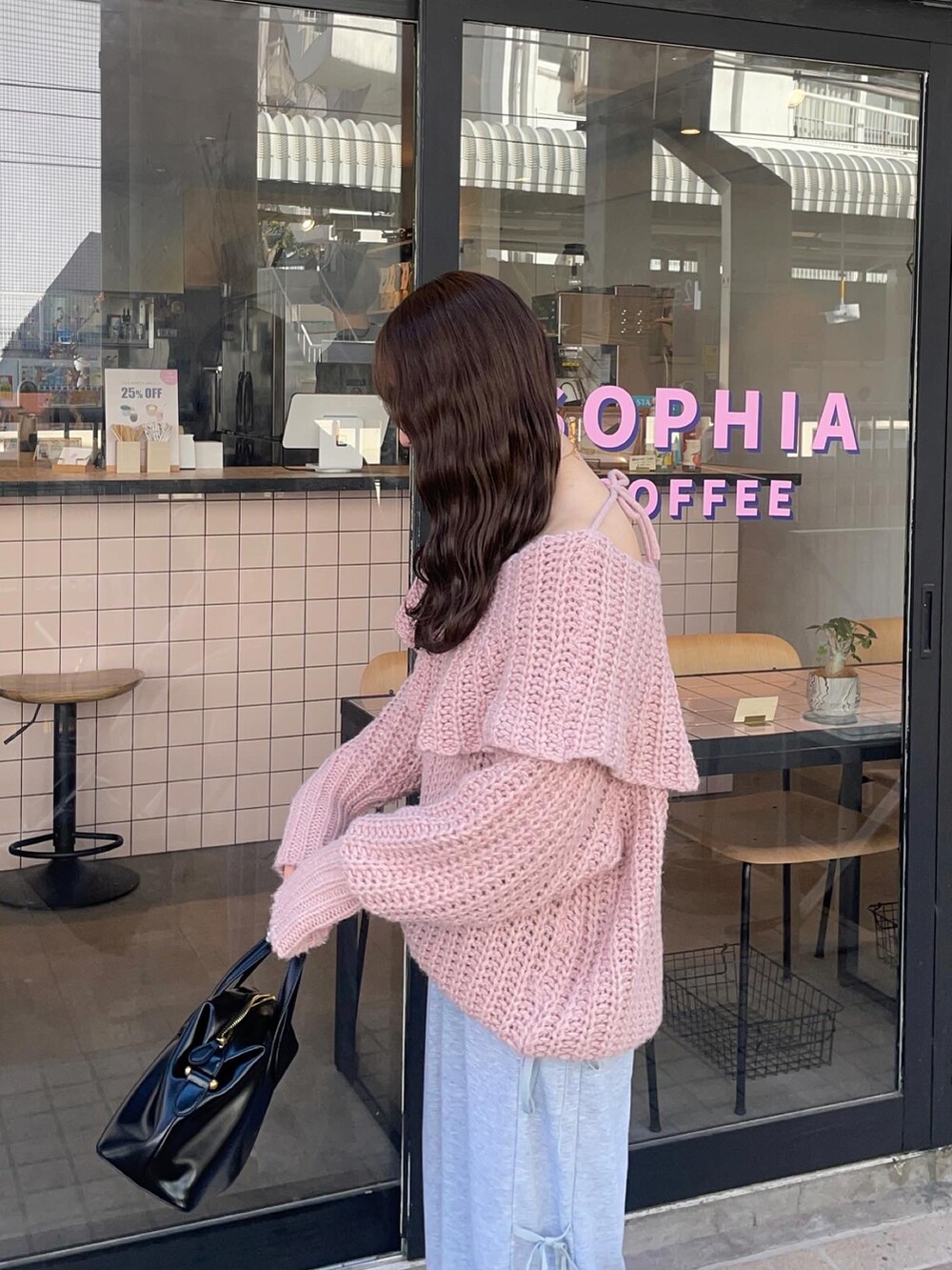 ピンク系のニット/セーター、ブラック系のスニーカーを着用したレディースの冬コーディネートの2枚目の写真