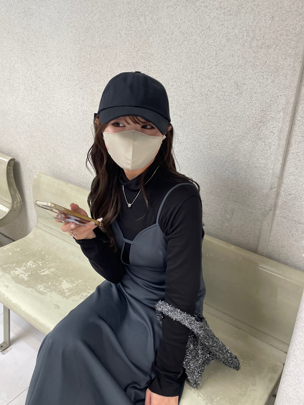 グレー系のワンピース、ブラック系のハンドバッグを着用したレディースの春コーディネートの2枚目の写真