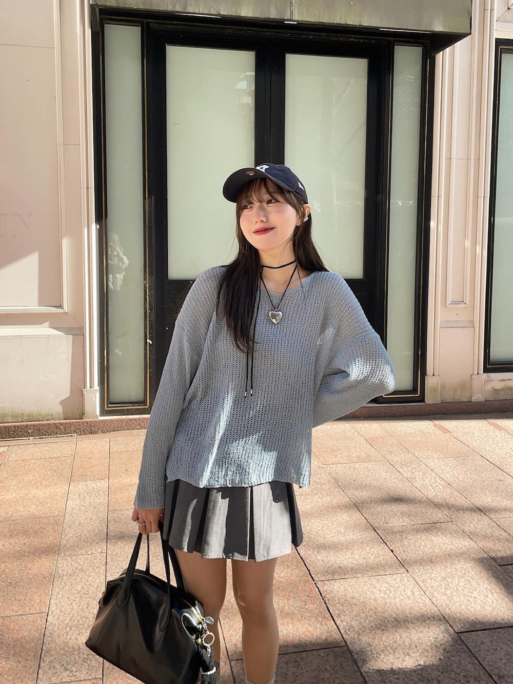 ブルー系のニット/セーター、ブラック系のハンドバッグ、ブラック系のスニーカーを着用したレディースの冬コーディネートの2枚目の写真