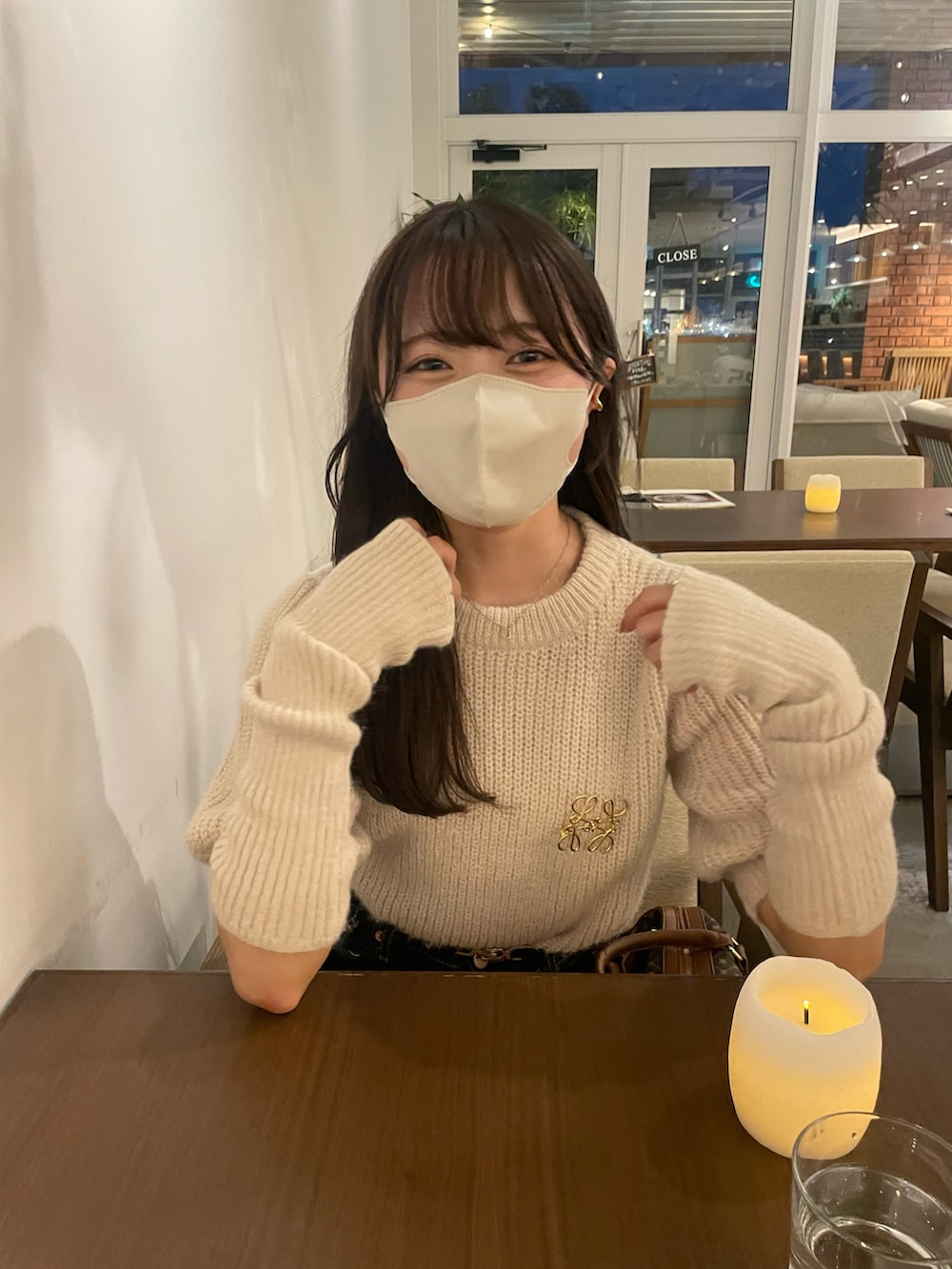 ブラウン系のショルダーバッグ、ホワイト系のニット/セーター、ブラック系のブーツを着用したレディースの秋コーディネートの4枚目の写真