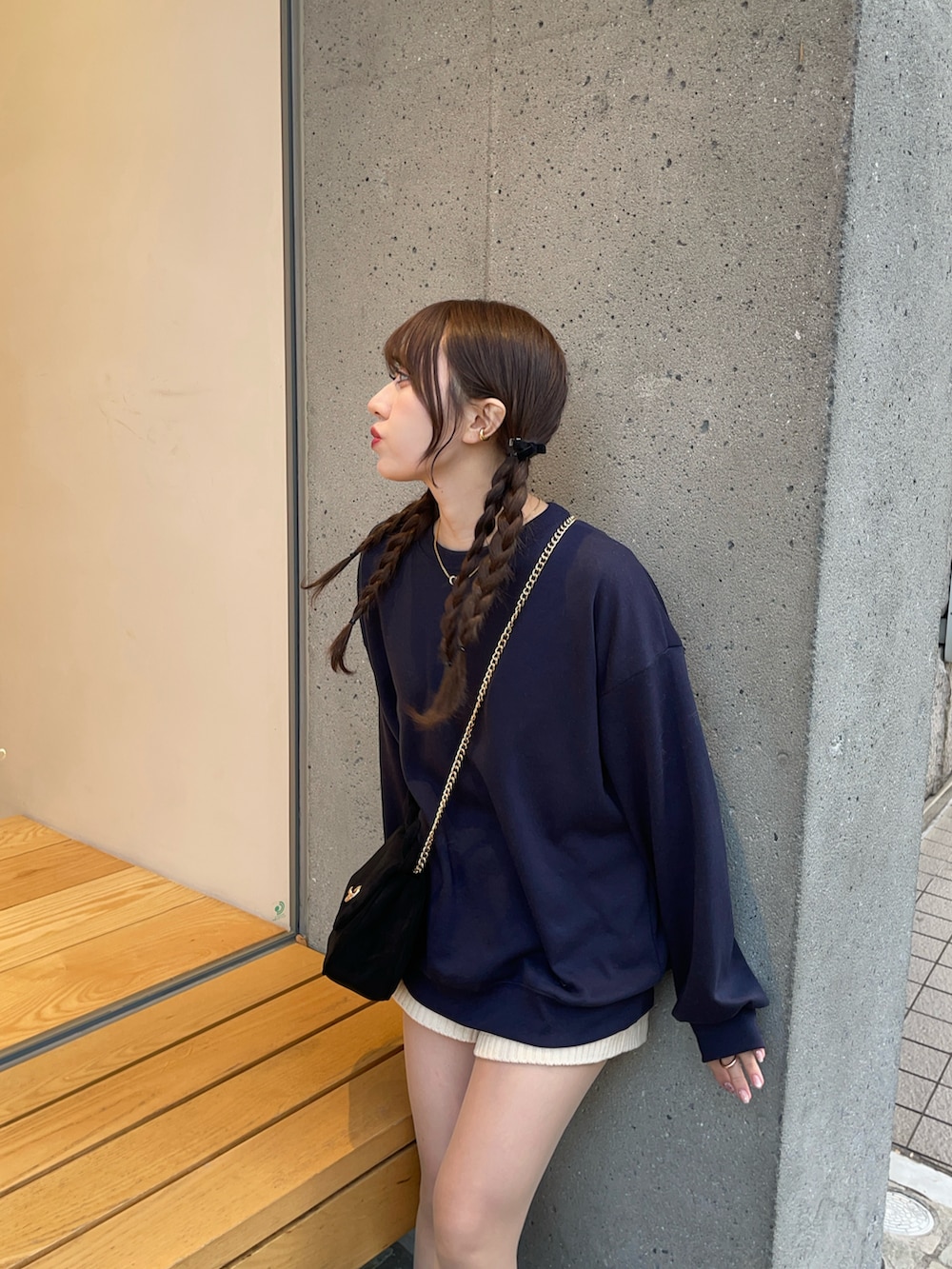 ブラック系のスニーカー、ブルー系のスウェット、ブラック系のショルダーバッグを着用したレディースの冬コーディネートの3枚目の写真