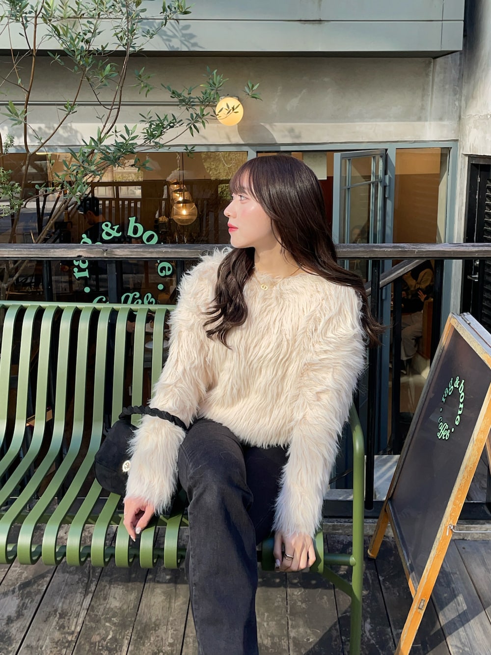 ベージュ系のブーツ、ブラック系のデニムパンツ、ベージュ系のニット/セーターを着用したレディースの冬コーディネートの4枚目の写真