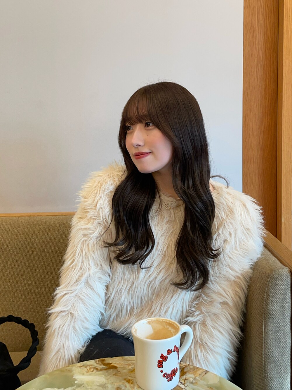 ベージュ系のブーツ、ブラック系のデニムパンツ、ベージュ系のニット/セーターを着用したレディースの冬コーディネートの2枚目の写真