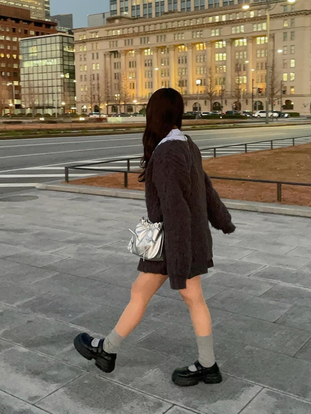 グレー系のカーディガン/ボレロ、ブルー系のシャツ/ブラウス、ブラック系のスニーカーを着用したレディースの冬コーディネートの3枚目の写真