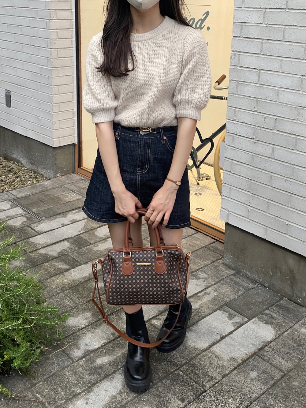 ブラウン系のショルダーバッグ、ホワイト系のニット/セーター、ブラック系のブーツを着用したレディースの秋コーディネートの3枚目の写真