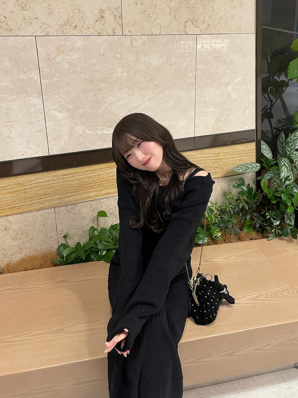 ブラック系のワンピース、ブラック系のショルダーバッグを着用したレディースの春コーディネートの3枚目の写真