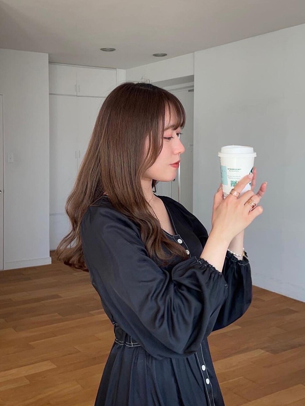 ブラック系のワンピースを着用したレディースの春コーディネートの2枚目の写真