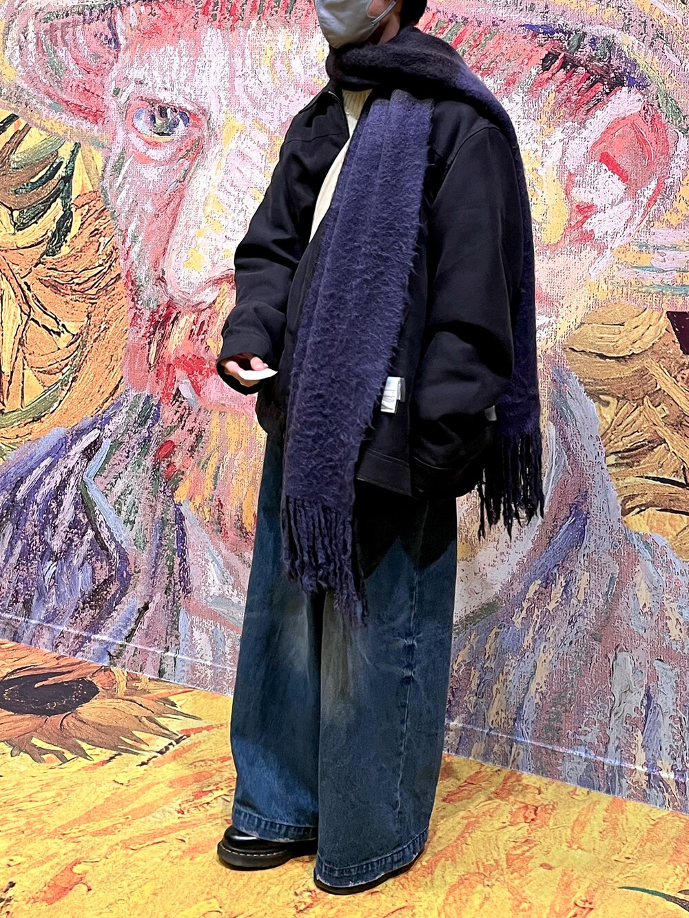 ブルー系のデニムパンツ、ホワイト系のドレスシューズ、ブルー系のマフラーを着用したメンズの冬コーディネートの2枚目の写真