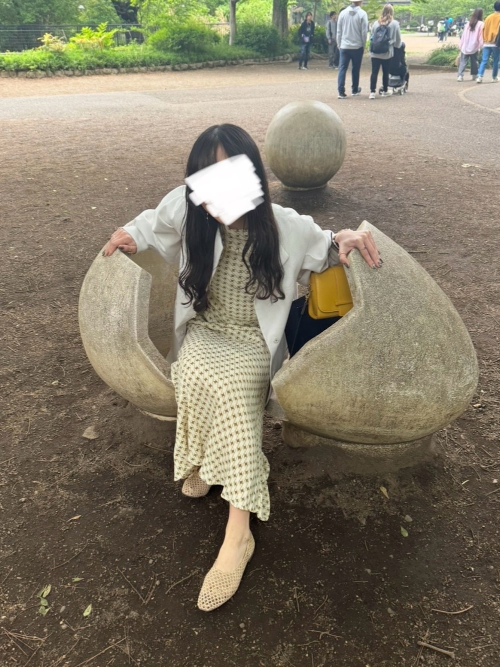 ベージュ系のワンピース、ホワイト系のテーラードジャケット、ベージュ系のバレエシューズを着用したレディースの春コーディネートの2枚目の写真