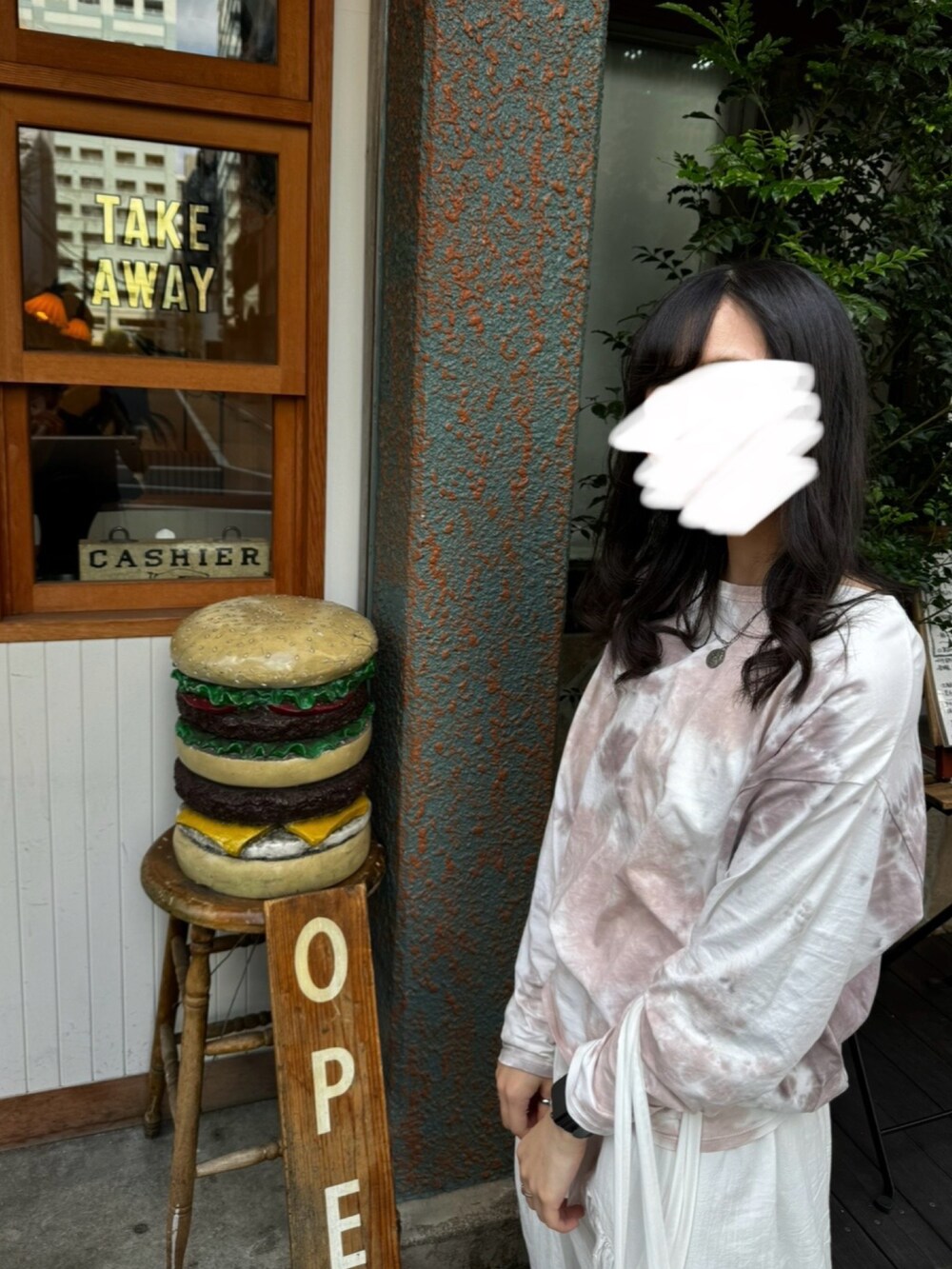 ブラウン系のTシャツ/カットソー、ホワイト系のスカート、ブラック系のスニーカーを着用したレディースの秋コーディネートの3枚目の写真