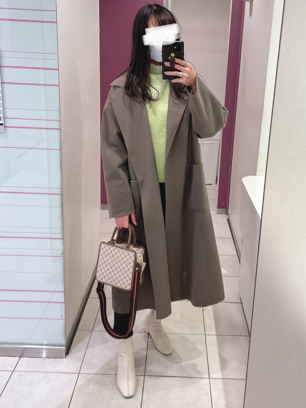 グリーン系のニット/セーター、ブラック系のデニムパンツ、ホワイト系のブーツを着用したレディースの冬コーディネートの2枚目の写真