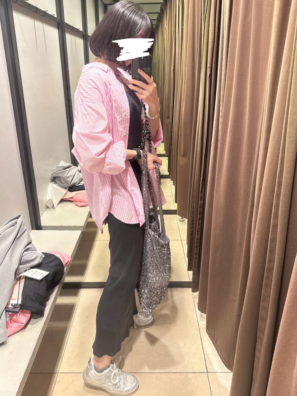 シルバー系のトートバッグ、ブラック系のワンピース、ホワイト系のブレスレットを着用したレディースの夏コーディネートの2枚目の写真