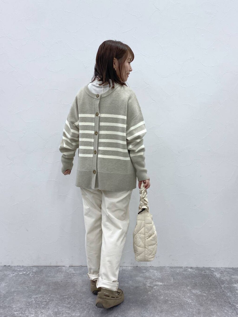 グレー系のTシャツ/カットソー、グレー系のモカシン/デッキシューズ、ベージュ系のトートバッグを着用したレディースの冬コーディネートの6枚目の写真