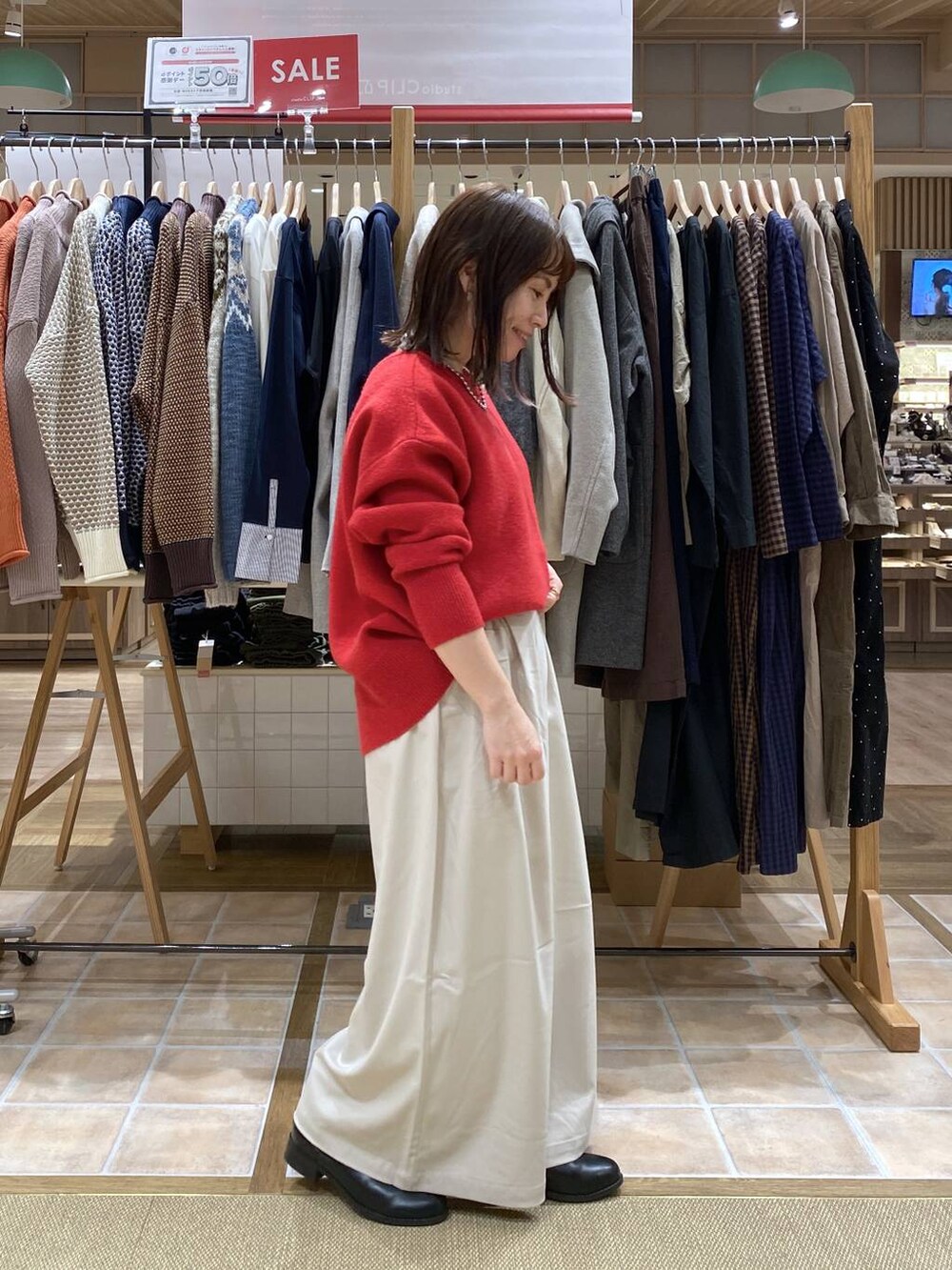 ブラック系のブーツ、ベージュ系のその他パンツ、レッド系のカーディガン/ボレロを着用したレディースの冬コーディネートの5枚目の写真