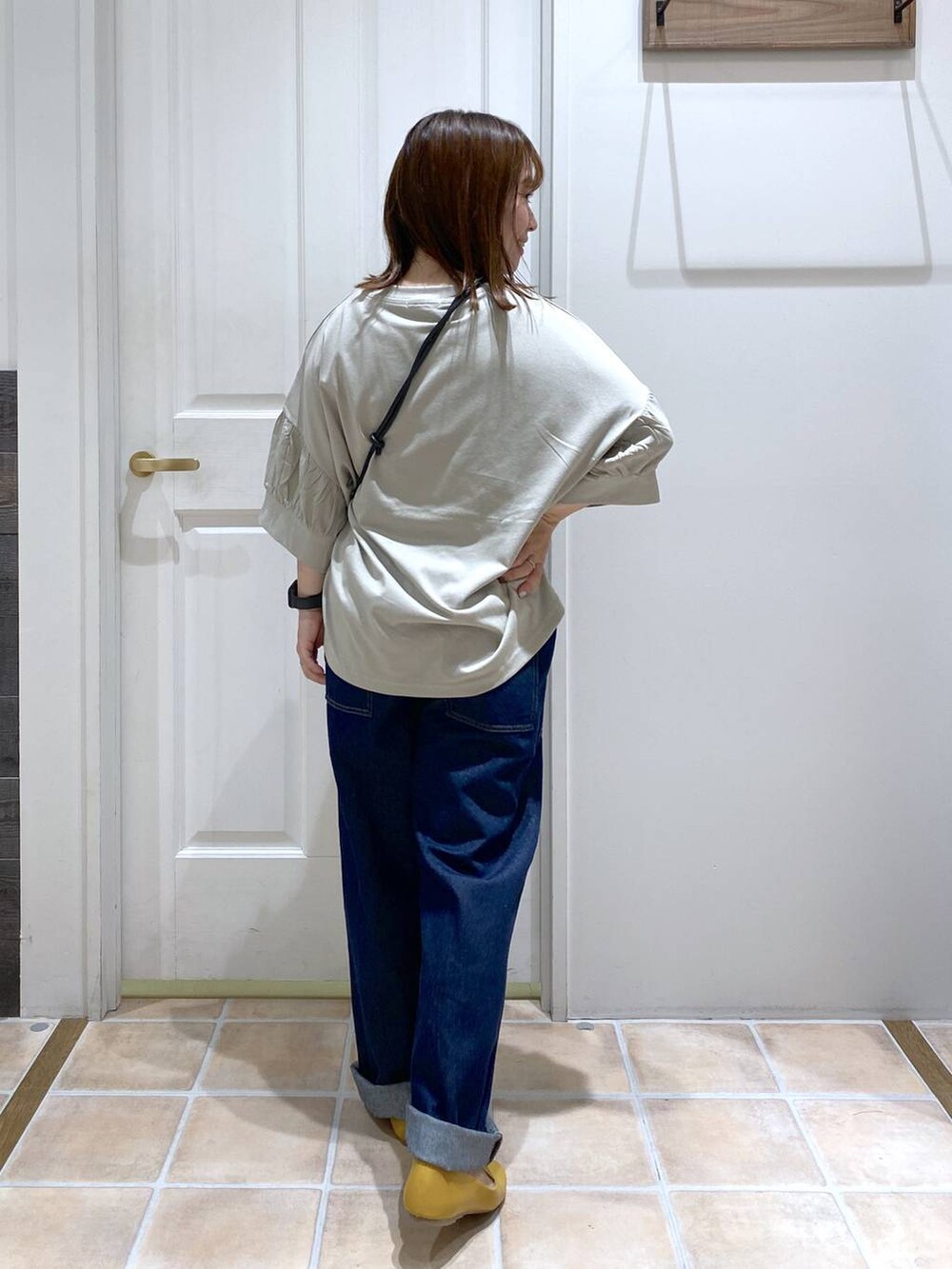 ベージュ系のタンクトップ、ブルー系のデニムパンツ、グリーン系のTシャツ/カットソーを着用したレディースの夏コーディネートの5枚目の写真