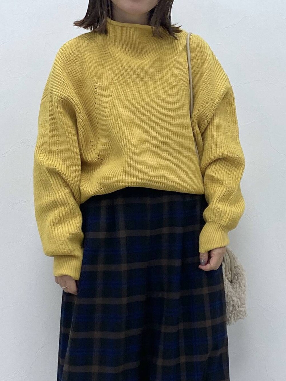 ブラック系のブーツ、イエロー系のニット/セーター、ベージュ系のトートバッグを着用したレディースの秋コーディネートの3枚目の写真