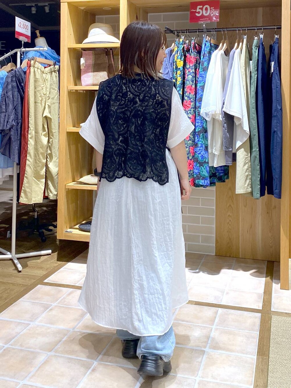 ブラック系のTシャツ/カットソー、ブラック系のサンダル、ブルー系のデニムパンツを着用したレディースの夏コーディネートの5枚目の写真