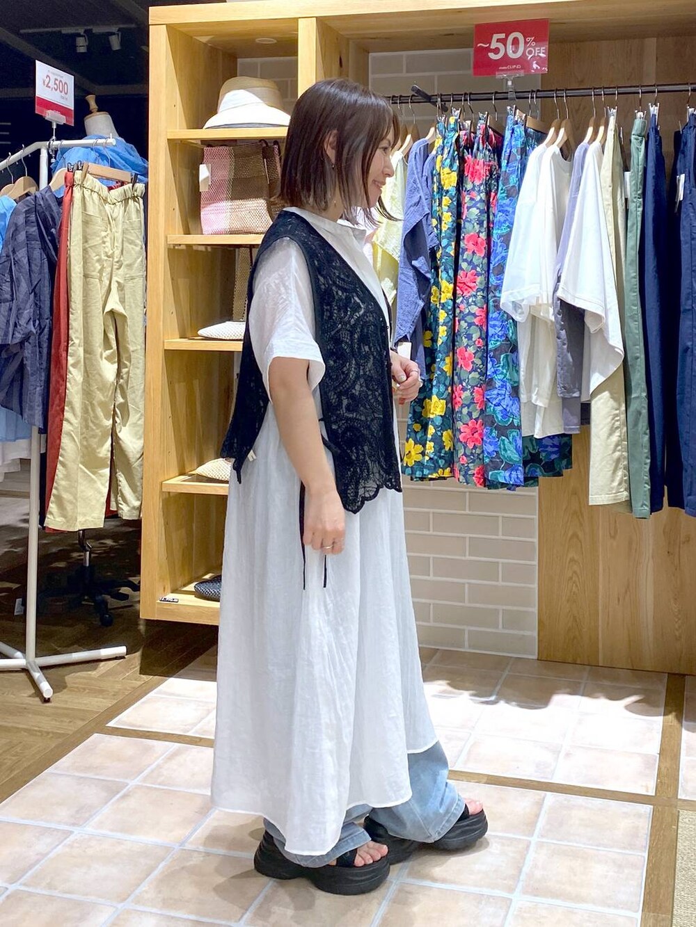 ブラック系のTシャツ/カットソー、ブラック系のサンダル、ブルー系のデニムパンツを着用したレディースの夏コーディネートの4枚目の写真