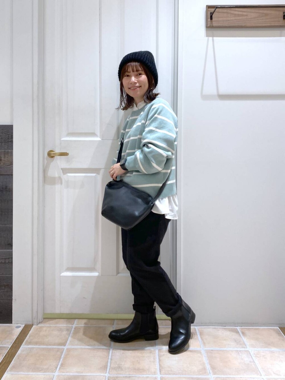 ブラック系のブーツ、グリーン系のニット/セーター、ブラック系のその他パンツを着用したレディースの冬コーディネートの3枚目の写真