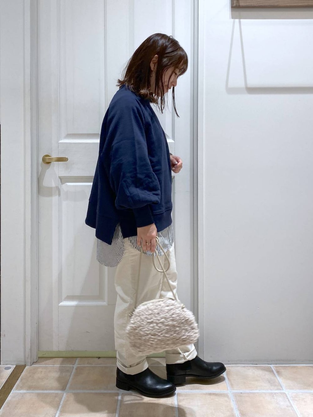 ブルー系のスウェット、ホワイト系のその他パンツ、ブラック系のブーツを着用したレディースの秋コーディネートの6枚目の写真