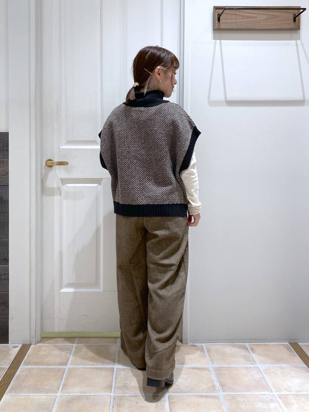 ホワイト系のTシャツ/カットソー、ブラック系のブーツ、ブラック系のベストを着用したレディースの秋コーディネートの5枚目の写真