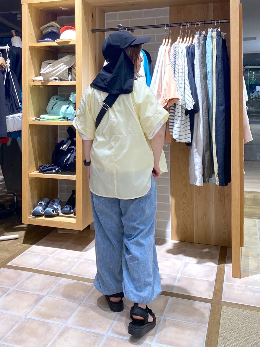 イエロー系のシャツ/ブラウス、ブラック系のサンダル、その他のTシャツ/カットソーを着用したレディースの春コーディネートの5枚目の写真