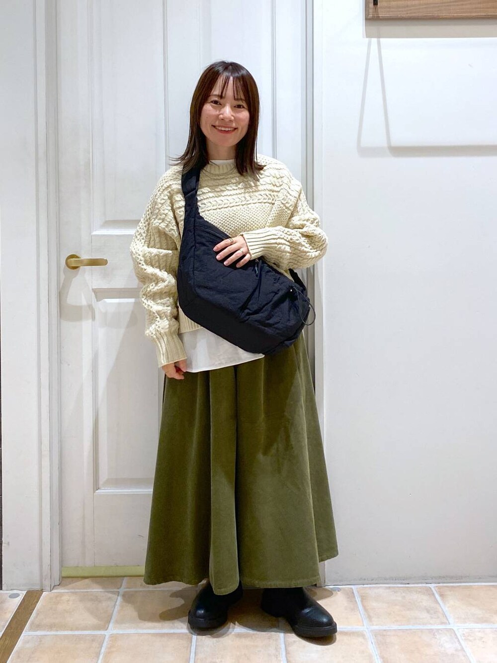 グリーン系のその他パンツ、ブラック系のブーツ、ブラック系のショルダーバッグを着用したレディースの冬コーディネートの2枚目の写真