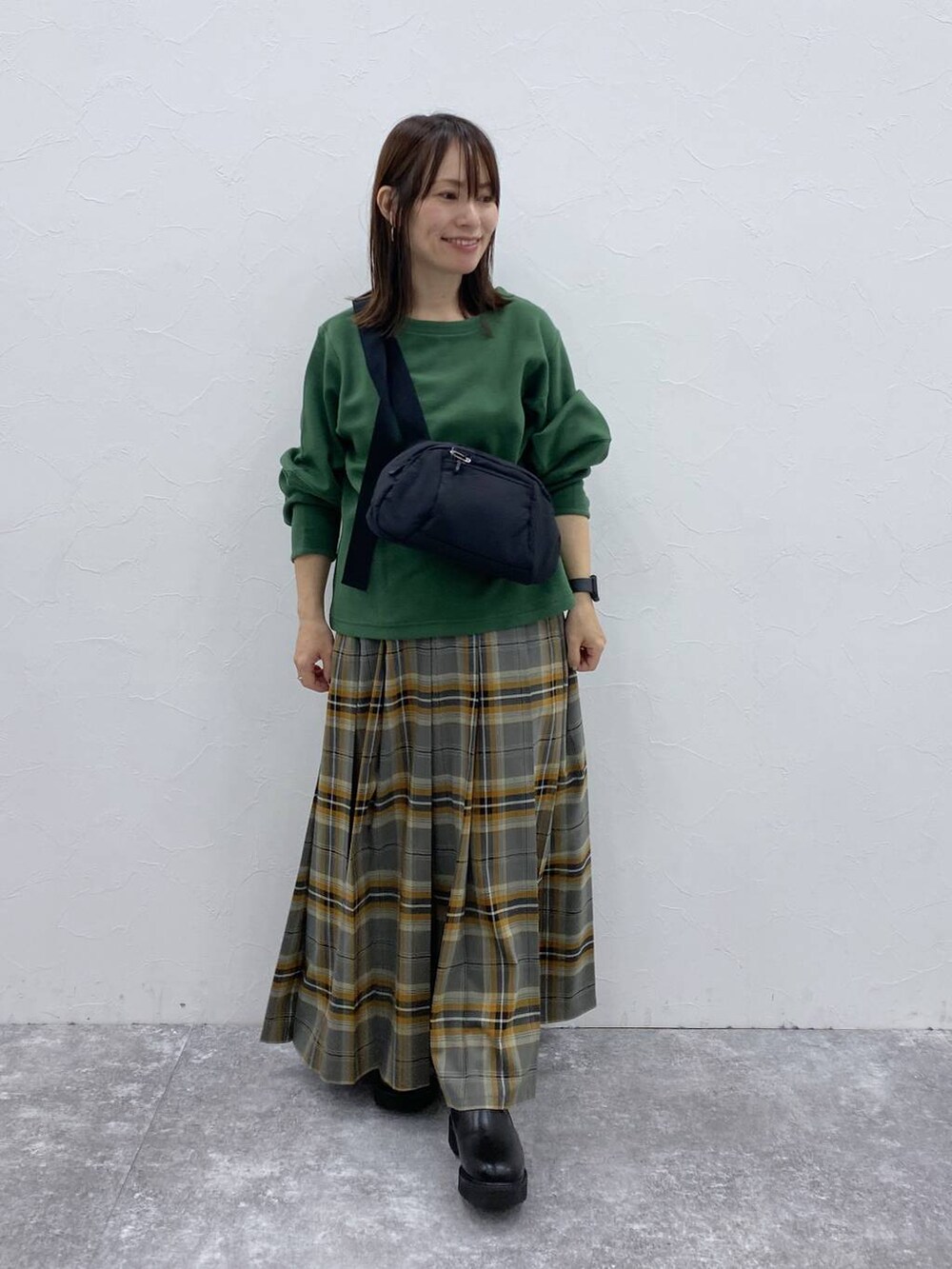 ブラック系のブーツ、ブラック系のショルダーバッグ、その他のスカートを着用したレディースの秋コーディネートの3枚目の写真