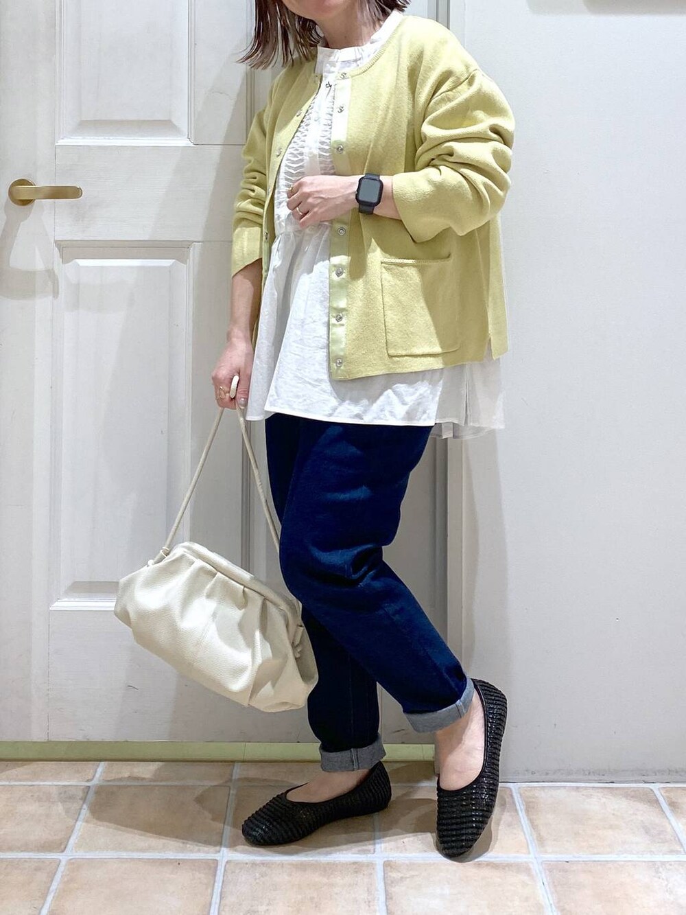 ホワイト系のショルダーバッグ、ブルー系のデニムパンツ、ホワイト系のビジネスシャツを着用したレディースの春コーディネートの3枚目の写真