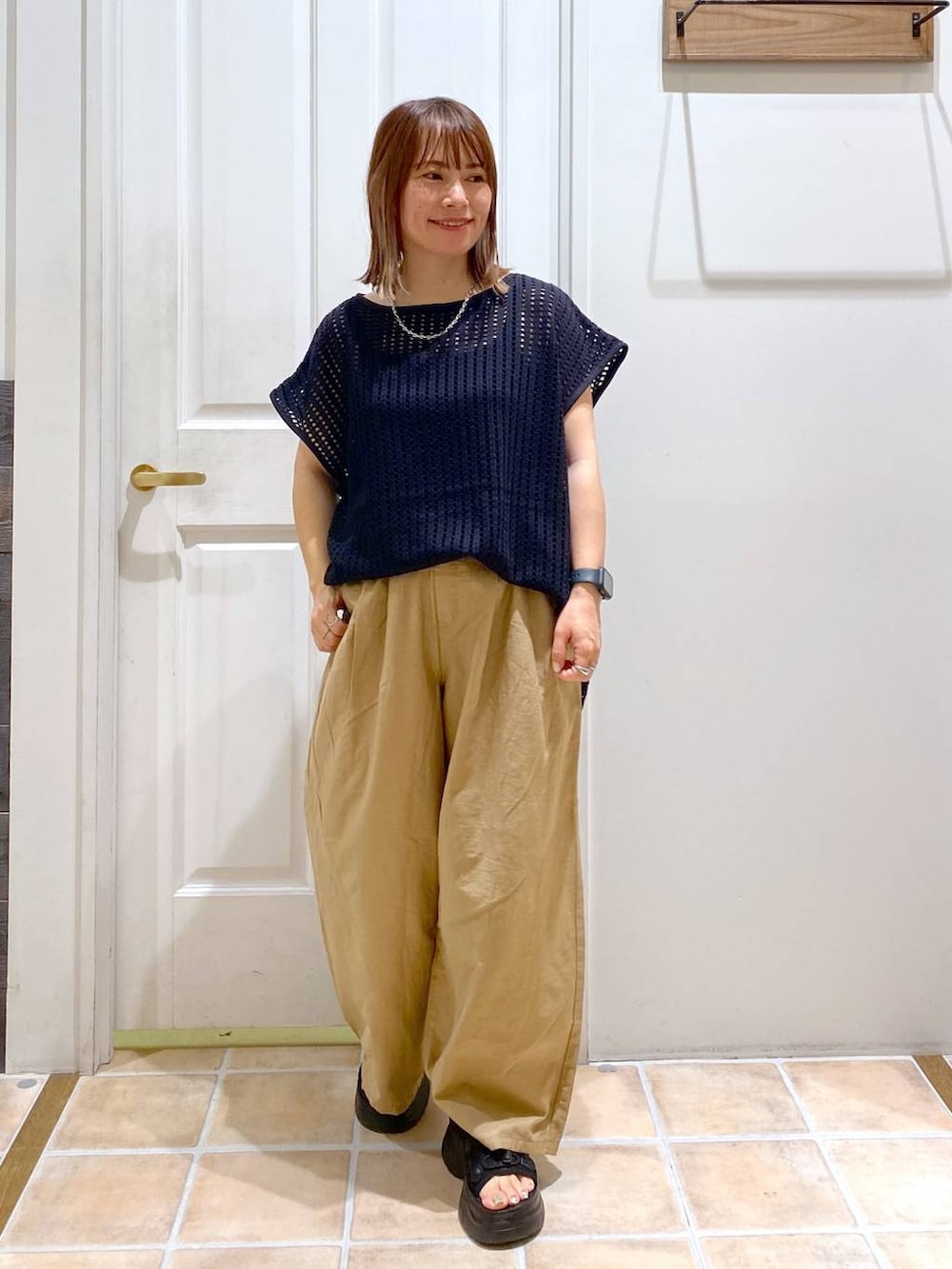 ブラック系のサンダル、ベージュ系のその他パンツ、ブラック系のTシャツ/カットソーを着用したレディースの夏コーディネートの3枚目の写真