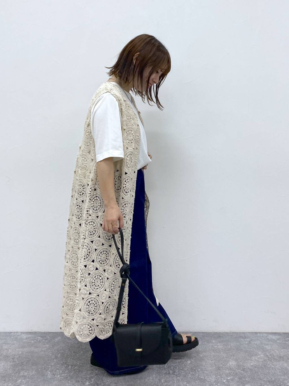 ブラック系のサンダル、ホワイト系のTシャツ/カットソー、ブラック系のショルダーバッグを着用したレディースの夏コーディネートの5枚目の写真