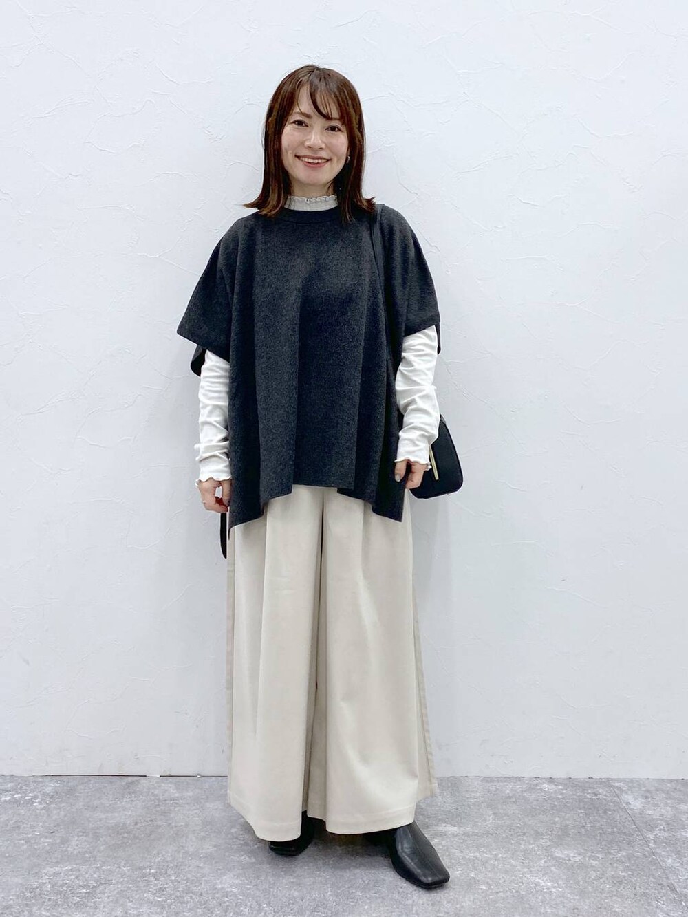 グレー系のTシャツ/カットソー、ブラック系のブーツ、ベージュ系のその他パンツを着用したレディースの冬コーディネートの2枚目の写真