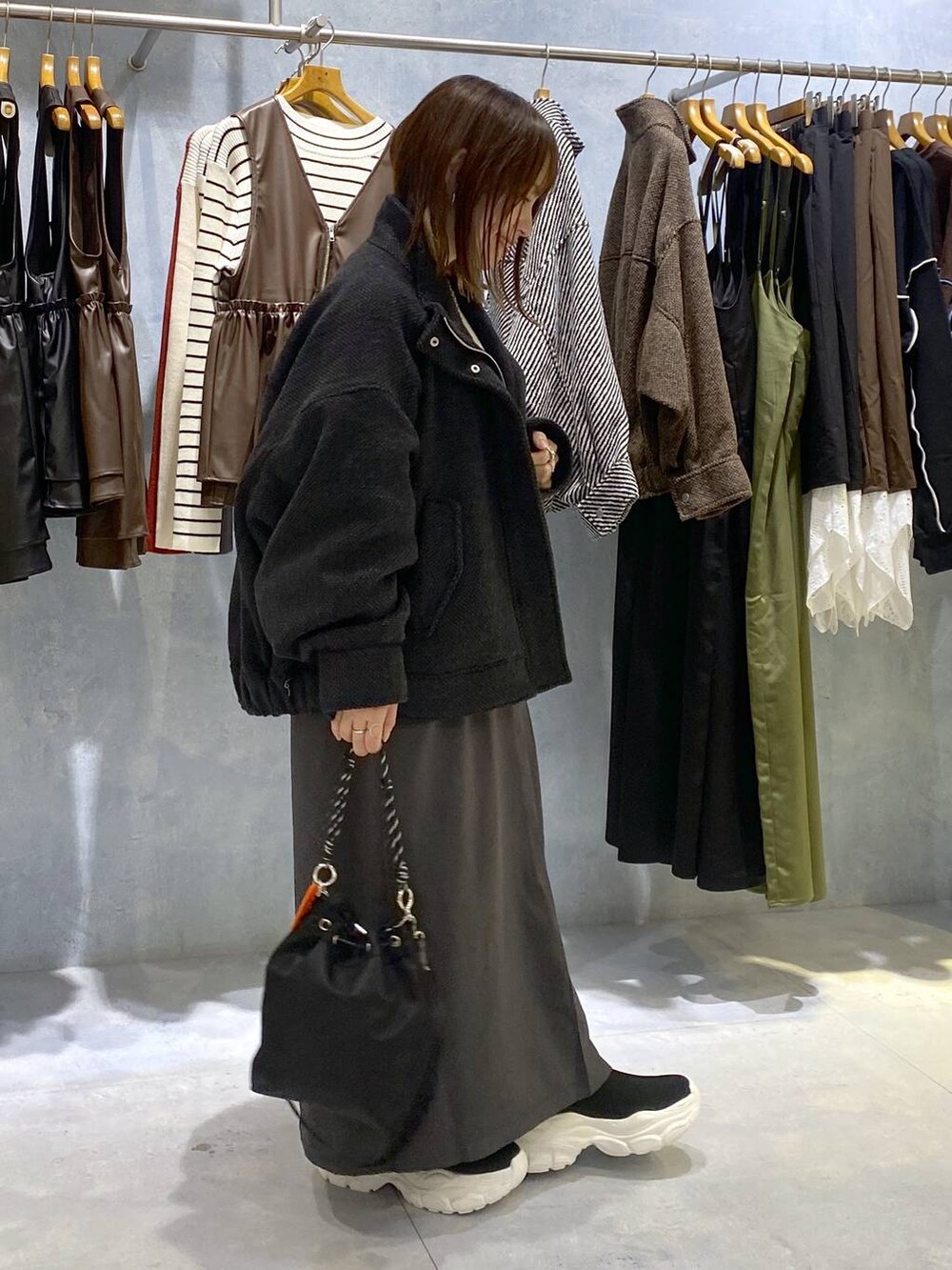 ブラック系のショルダーバッグ、ブラック系のニット/セーター、ホワイト系のニット/セーターを着用したレディースの秋コーディネートの4枚目の写真