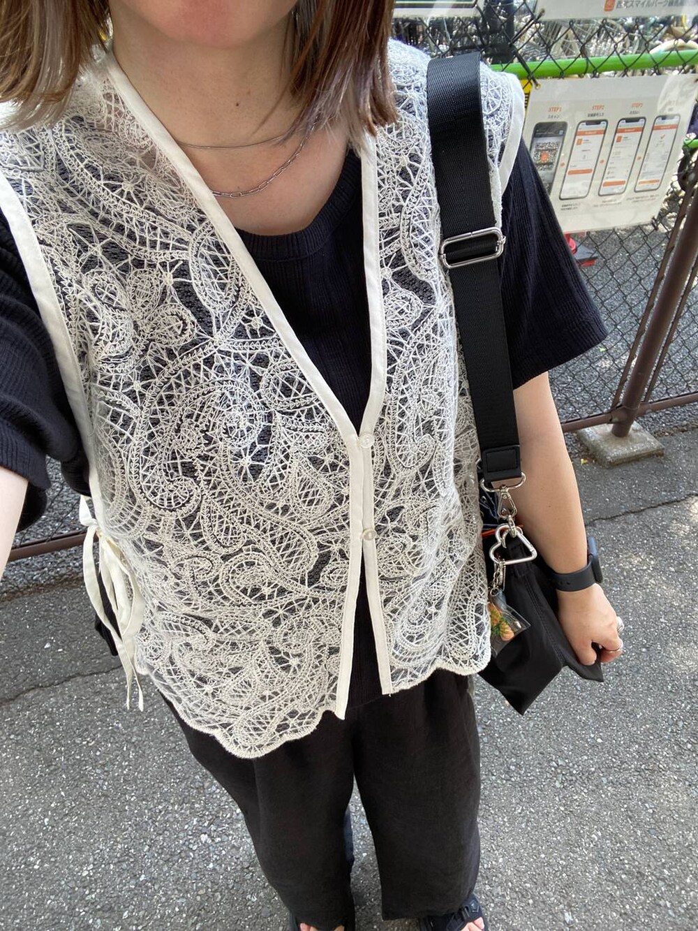 ブラック系のサンダル、ブラック系のTシャツ/カットソー、ブラック系のショルダーバッグを着用したレディースの夏コーディネートの3枚目の写真