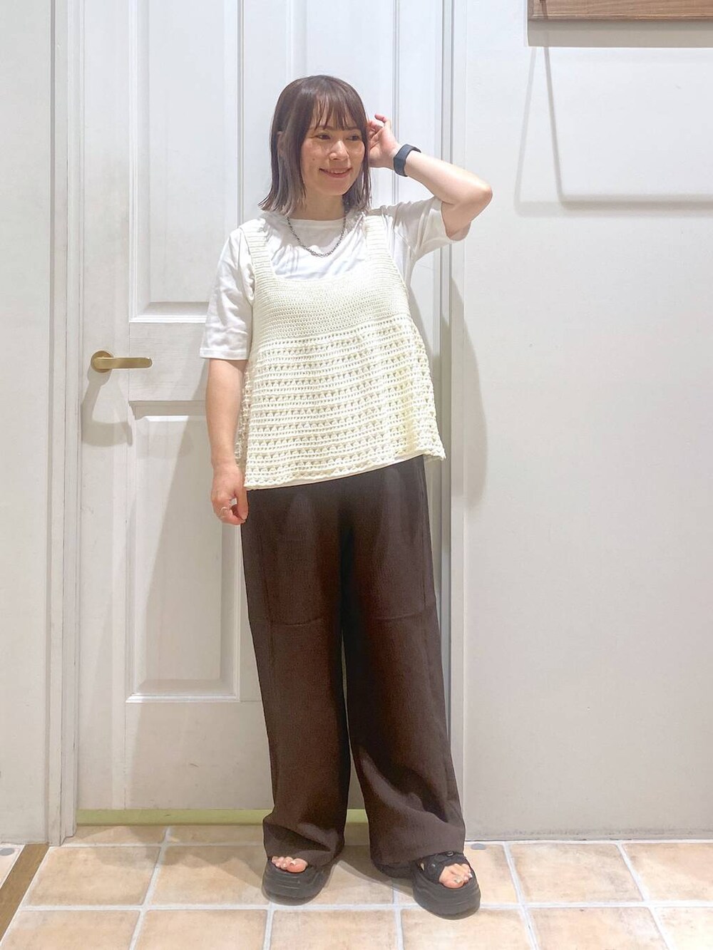 ブラック系のサンダル、ブラウン系のその他パンツ、ホワイト系のTシャツ/カットソーを着用したレディースの秋コーディネートの2枚目の写真