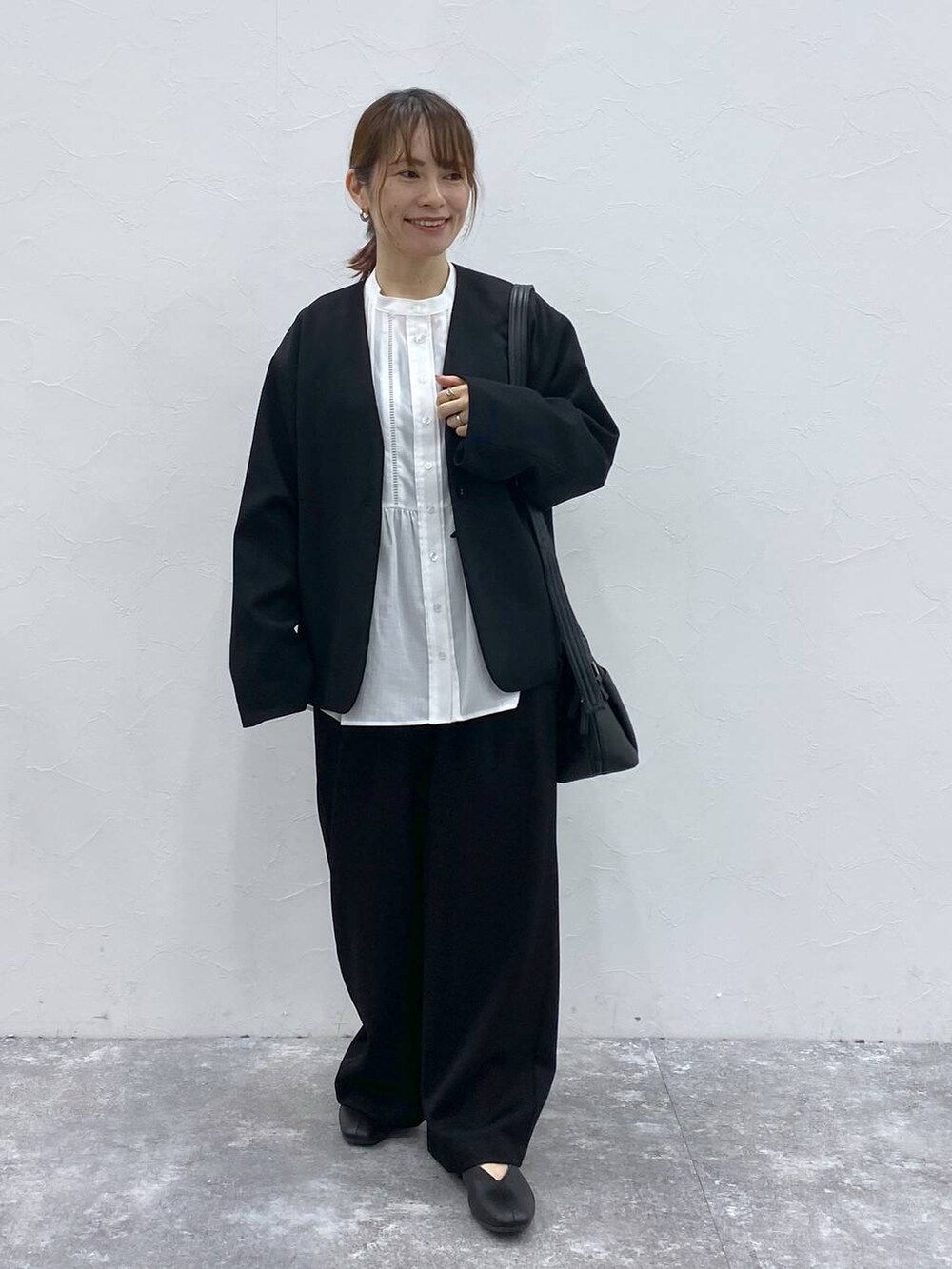 ブラック系のショルダーバッグ、ブラック系のノーカラージャケット、ホワイト系のシャツ/ブラウスを着用したレディースの冬コーディネートの4枚目の写真