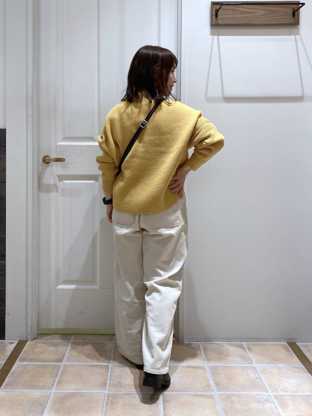 ホワイト系のその他パンツ、ブラック系のブーツ、イエロー系のニット/セーターを着用したレディースの冬コーディネートの6枚目の写真